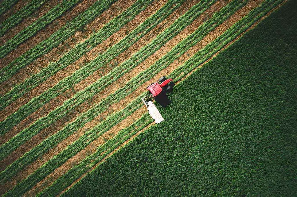 Aerial photo of a tractor mowing green field in Bulgaria